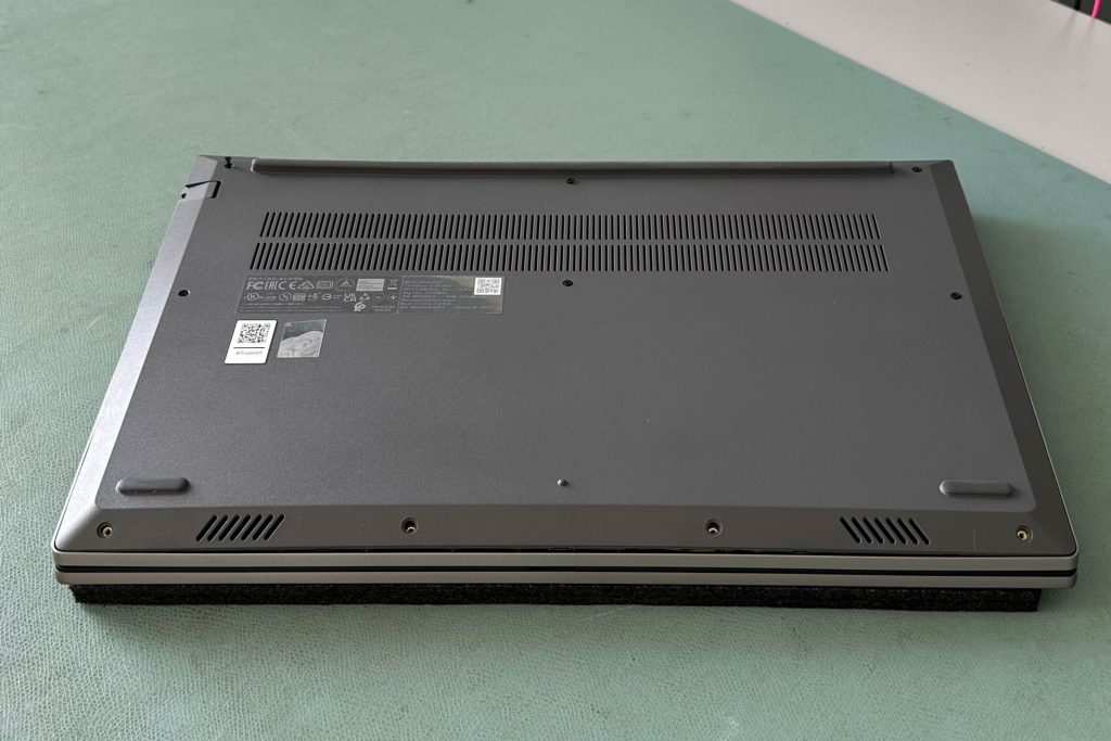 Ein Notebook liegt auf einer grünen ESD-Matte, auf der Bildschirmseite nach unten und geschlossen. Die ESD-Matte sorgt für sicheren Schutz vor elektrostatischen Entladungen während der Reparatur oder Wartung des Geräts.